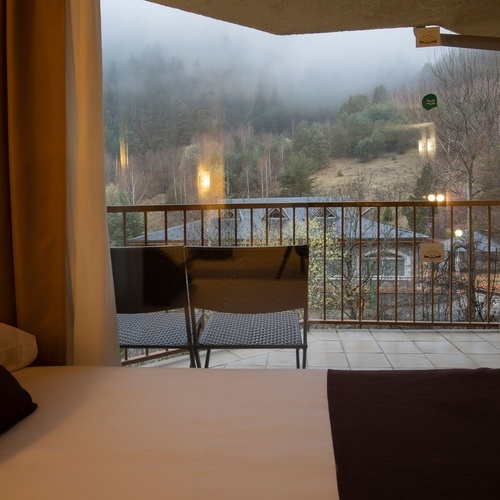 a hotel room with a balcony and a green sticker on the door