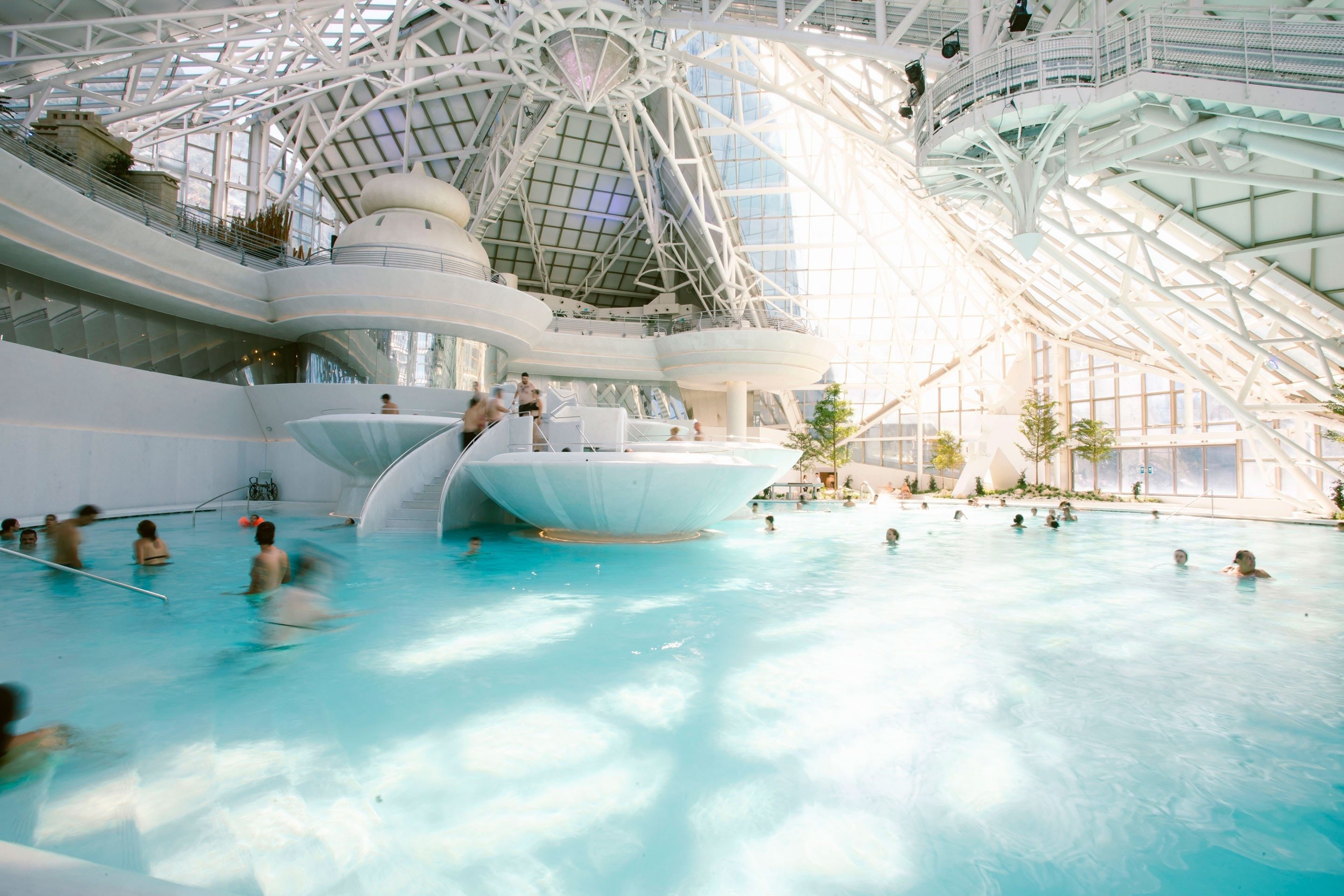 a group of people are swimming in a large indoor pool