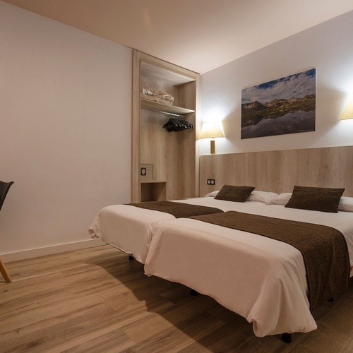 una habitación con dos camas y una pintura en la pared