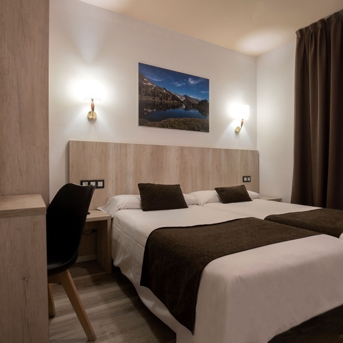 una habitación de hotel con dos camas y un cuadro en la pared