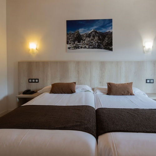una habitación con dos camas y una pintura en la pared
