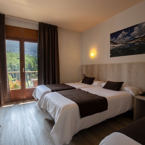 una habitación con tres camas y una pintura en la pared