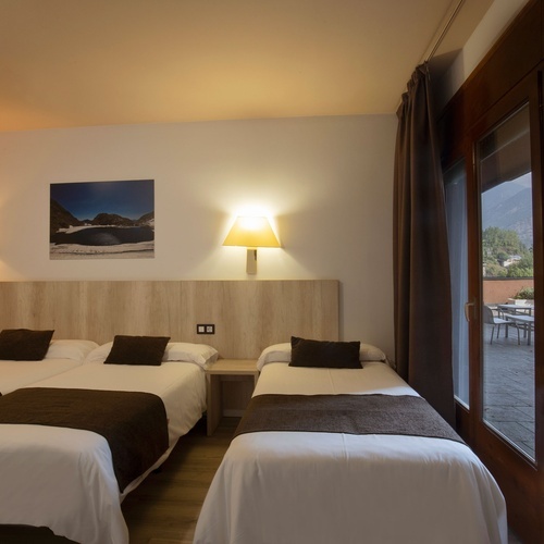 una habitación con tres camas y una pintura en la pared