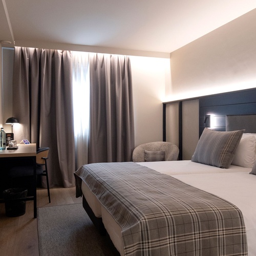 una habitació d' hotel amb un llit i una cadireta