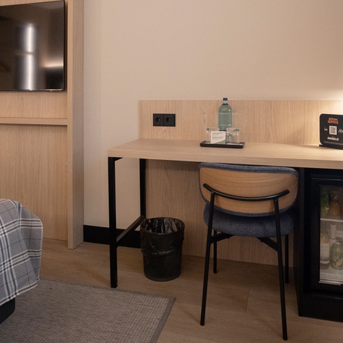una habitació d' hotel amb un escritó i un refrigerador