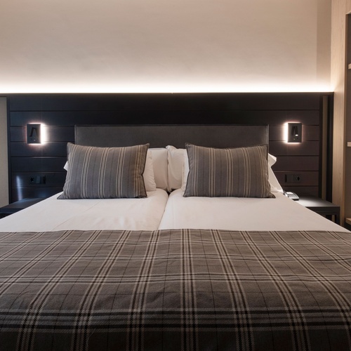 una habitació d' hotel amb un llit i una cadireta
