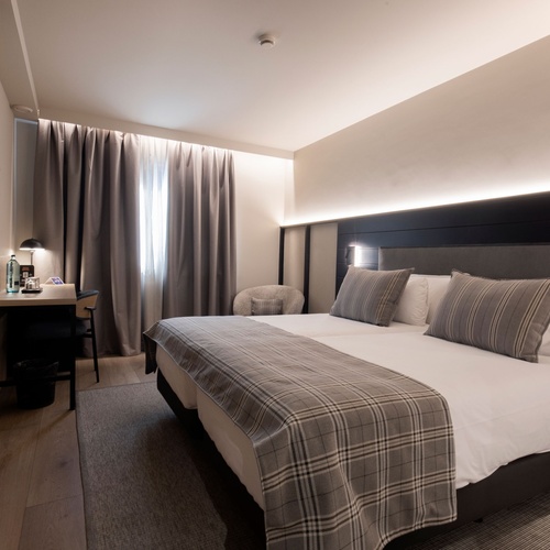 una habitació d' hotel amb dues camas i una televisió