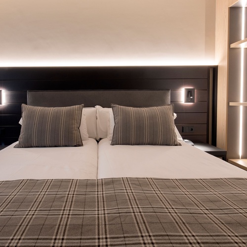 una habitació d' hotel amb un llit i un plaid