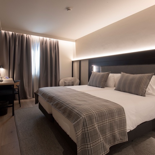 una habitació d' hotel amb un llit i una cadireta