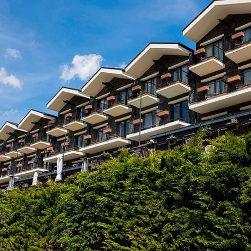 un gran edificio con muchos balcones está rodeado de árboles