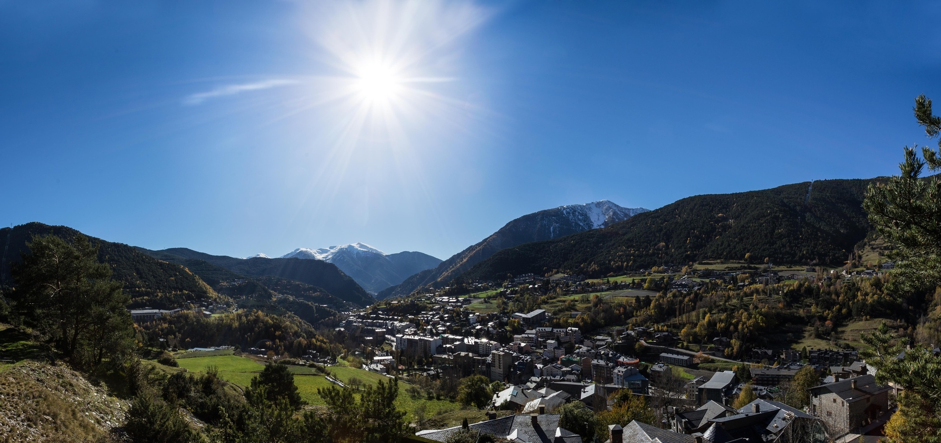 the sun shines brightly over a small town in the mountains