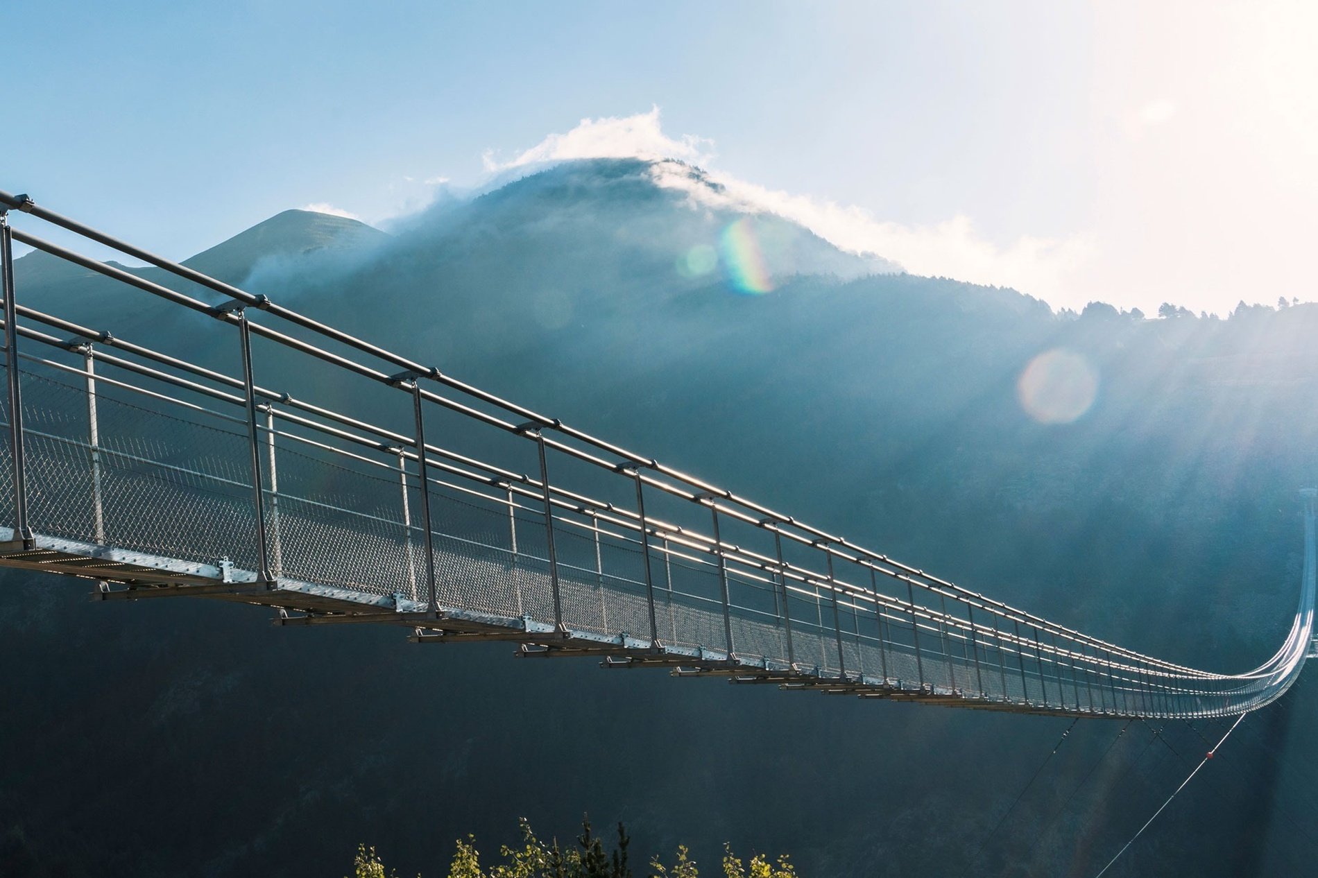 un pont suspendu avec une montagne en arrière-plan