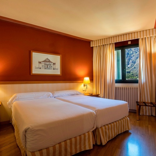 a hotel room with two beds and a picture of a building on the wall