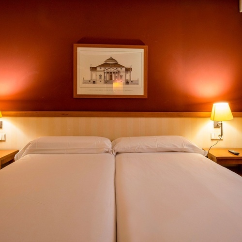 a picture of a building hangs above a bed in a hotel room