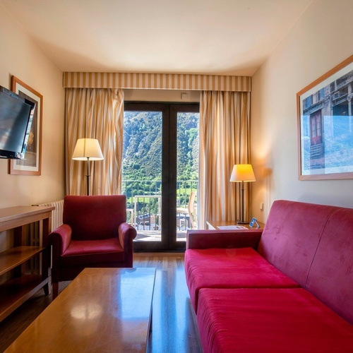 a living room with a red couch and a flat screen tv