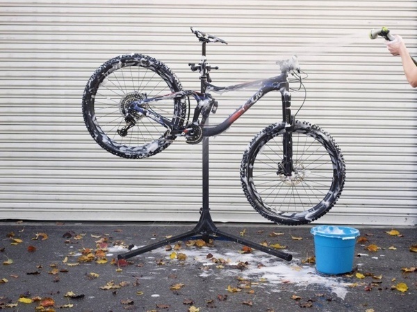 a bicycle is being cleaned with soap and a blue bucket