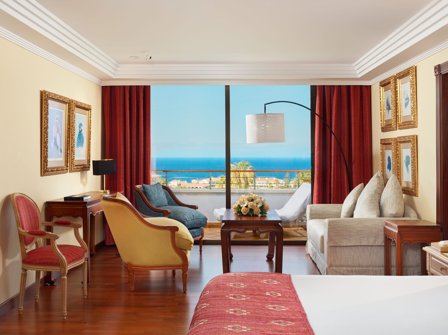 Ein luxuriöses Hotelzimmer mit Wohnbereich und atemberaubendem Meerblick.