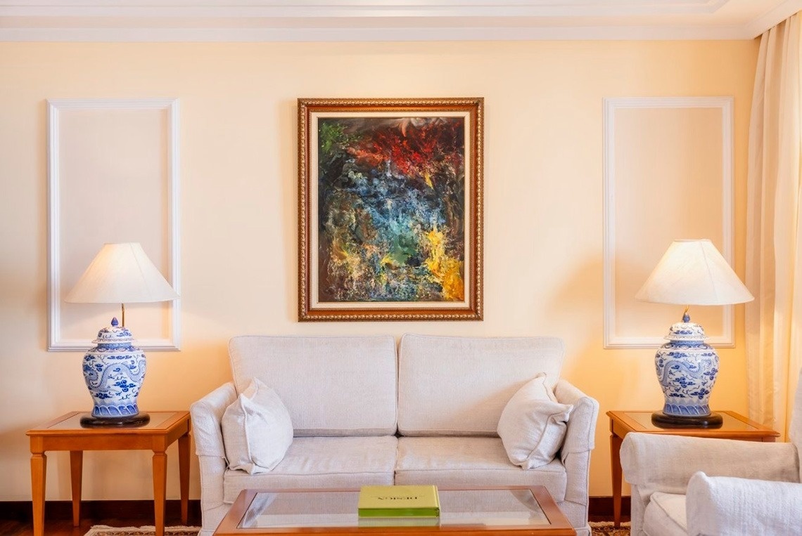 una sala de estar con una mesa y sillas y una pintura en la pared