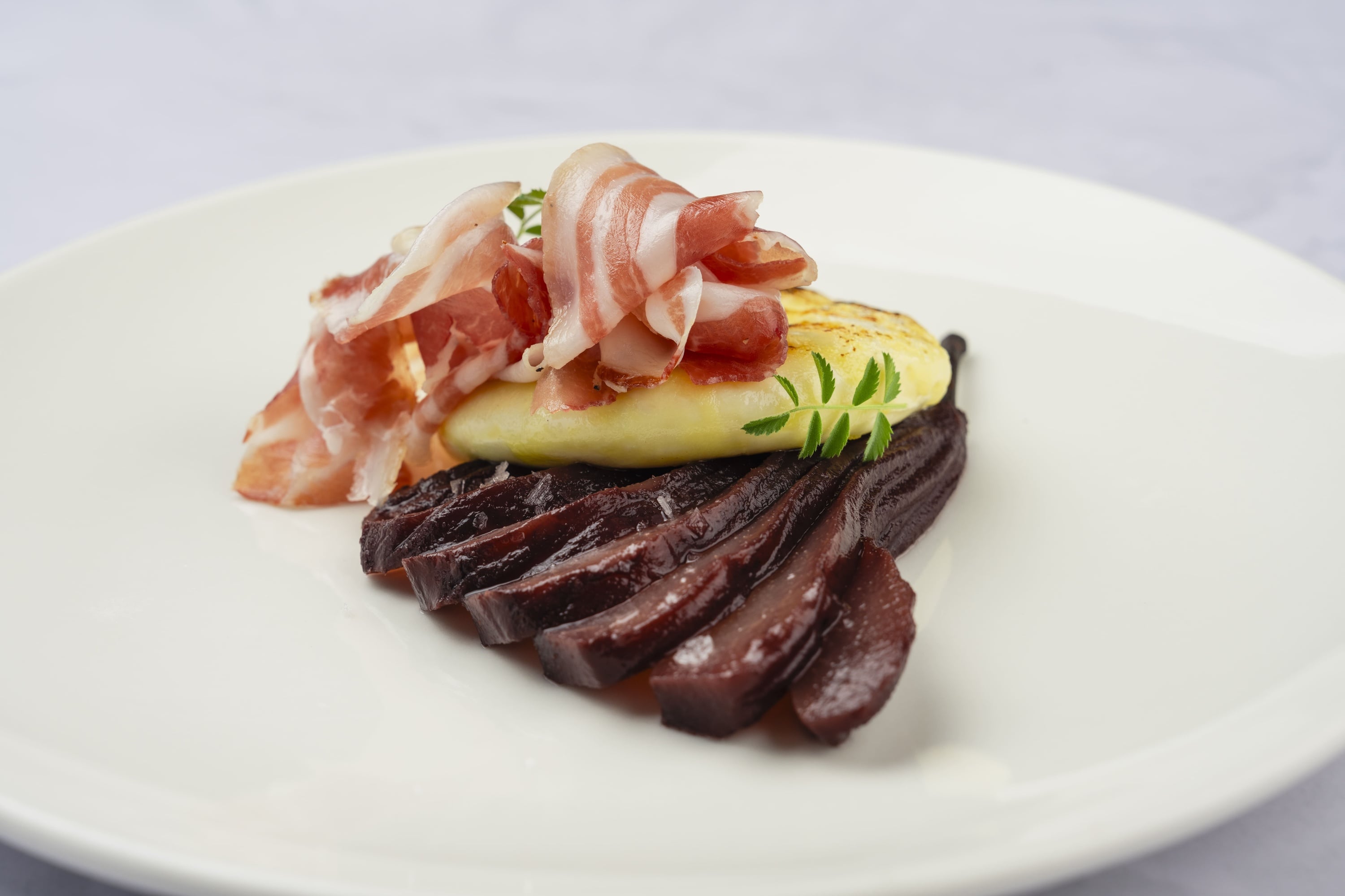 it Una scena serena di persone che cenano su una terrazza panoramica al tramonto, sotto grandi ombrelloni rossi.