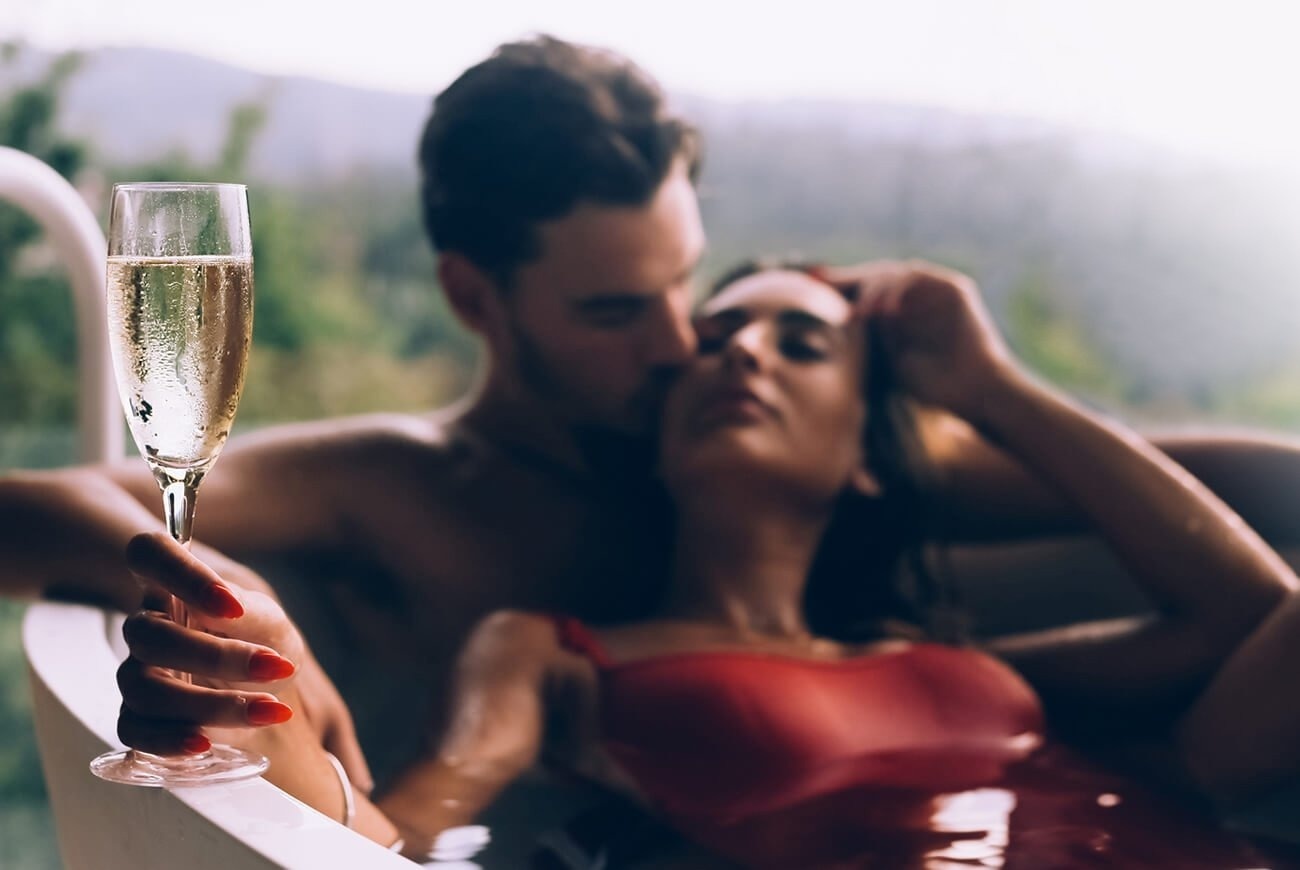 una mujer está sentada en una mesa comiendo pasta y bebiendo vino