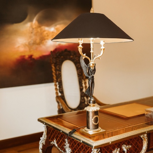 Un affollato gruppo di figure in abiti tradizionali è ritratto in un paesaggio costiero, con alcuni che trasportano frutta e altri che riposano.