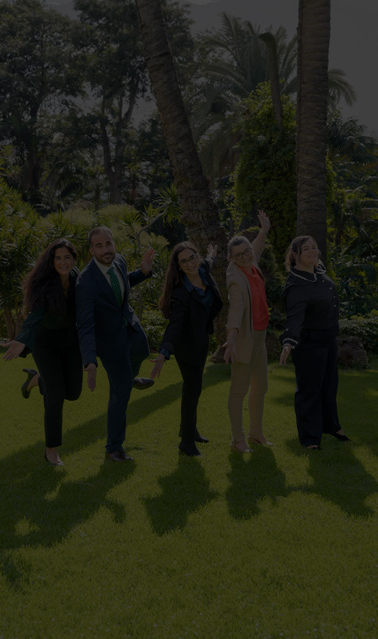 Il team dell'Hotel Botanico posa giocosamente in un giardino tropicale.