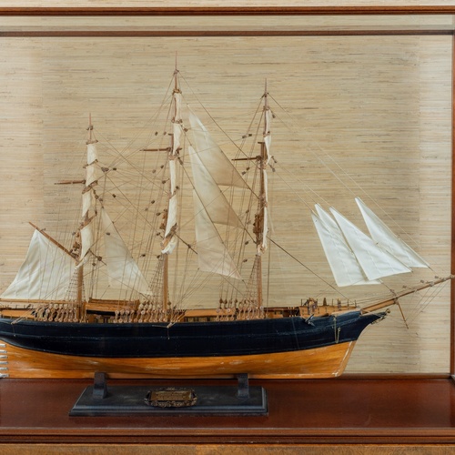 Un affollato gruppo di figure in abiti tradizionali è ritratto in un paesaggio costiero, con alcuni che trasportano frutta e altri che riposano.