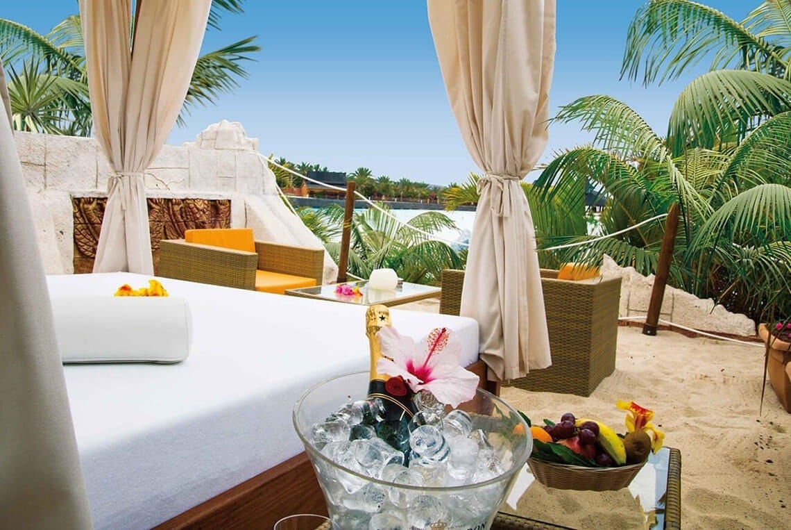 kobieta siedzi przy stole, jedząc makaron i pijąc wino