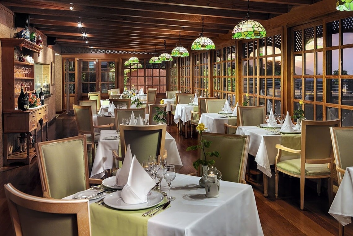 una donna è seduta a un tavolo mentre mangia pasta e beve vino