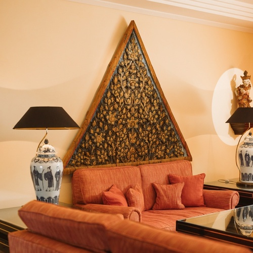 Un affollato gruppo di figure in abiti tradizionali è ritratto in un paesaggio costiero, con alcuni che trasportano frutta e altri che riposano.