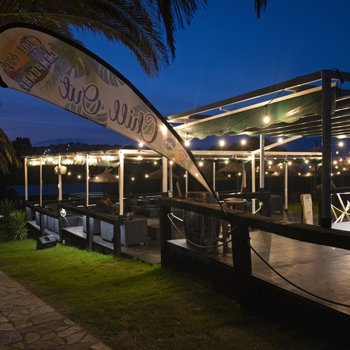 una tienda de comida al aire libre está iluminada por la noche