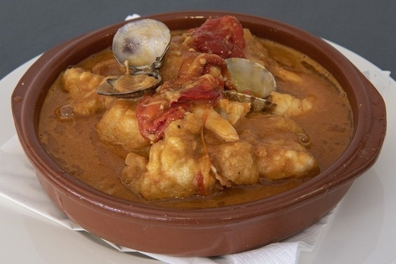 un tazón marrón lleno de comida en un plato blanco