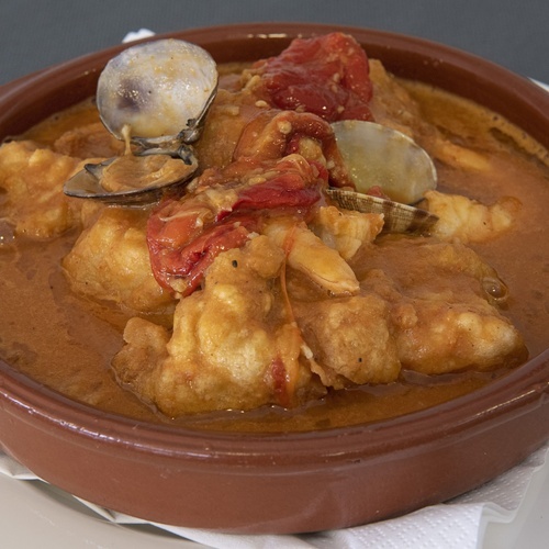 un tazón marrón lleno de comida en un plato blanco