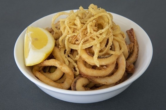 un tazón de calamares fritos con una rodaja de limón