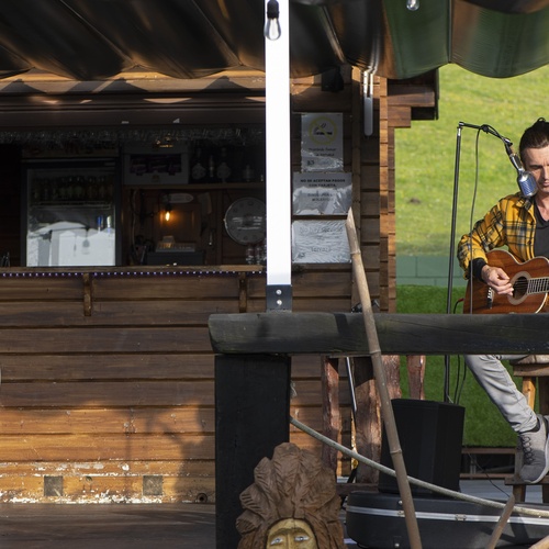 un hombre toca la guitarra frente a un cartel que dice chill out