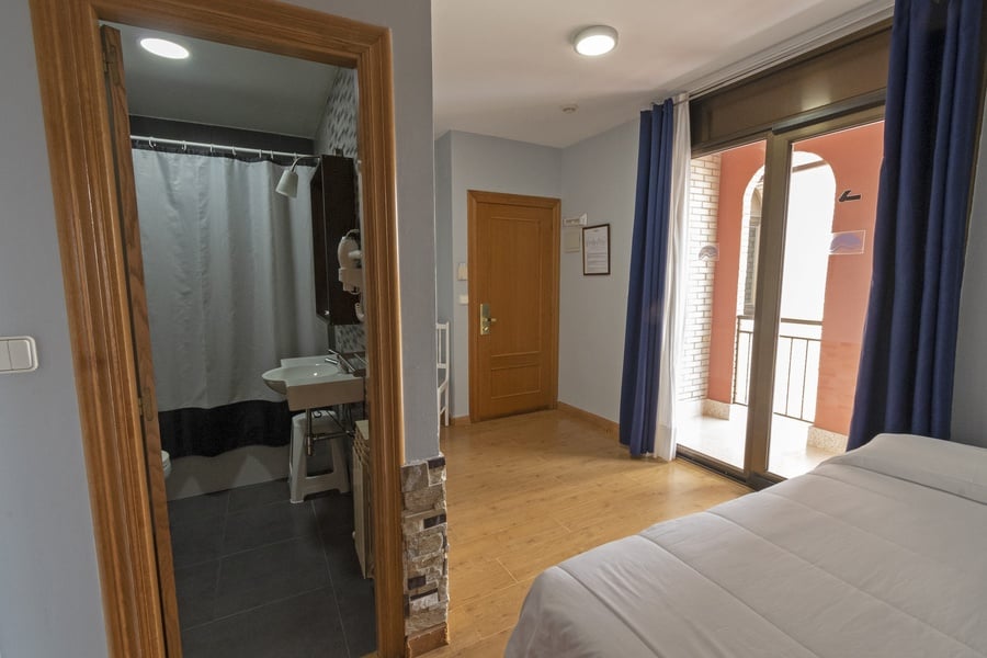 una habitación con una cama y una puerta que conduce a un baño