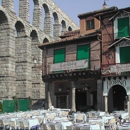 tables and chairs are set up in front of a building that says horno asap