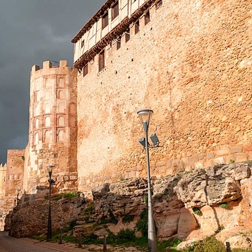 a stone wall with a building in the background