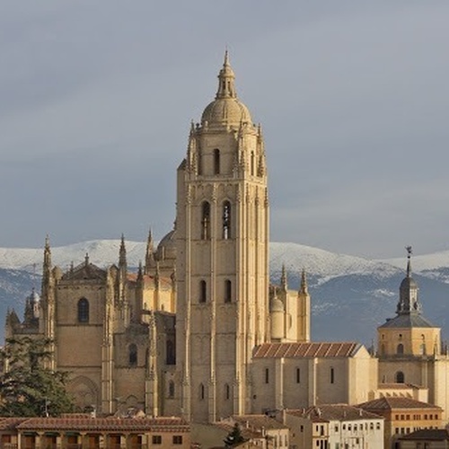 una catedral con montañas cubiertas de nieve en el fondo