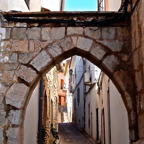 un arco de piedra que conduce a la plaza de la puerta