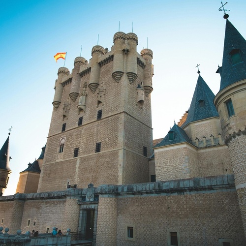ein großes mittelalterliches Schloss mit einer Flagge an der Spitze