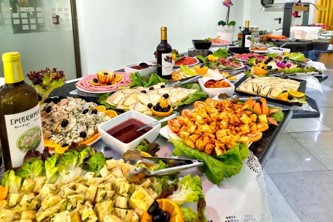 ein Buffettisch mit vielen Speisen und einer Flasche embruno Wein