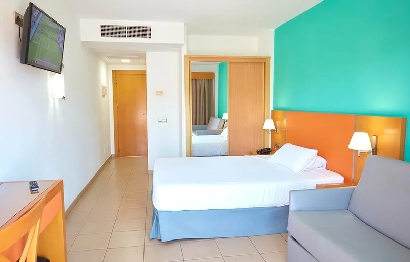 a hotel room with a large bed and a flat screen tv