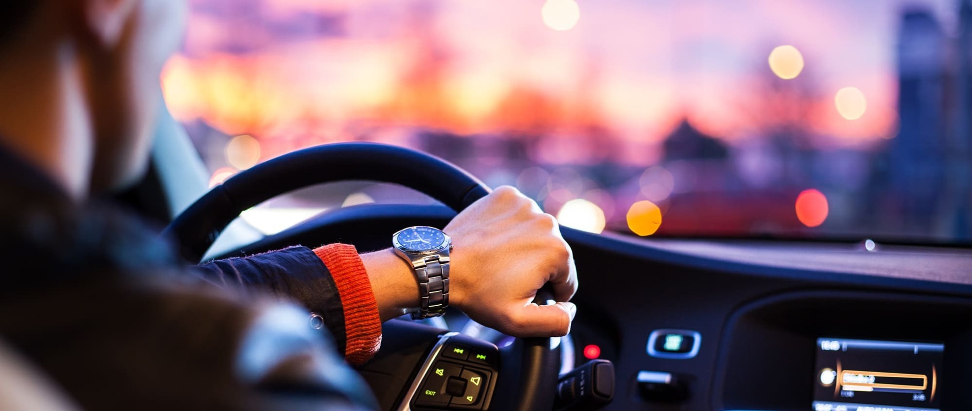 a man wearing a watch is driving a car
