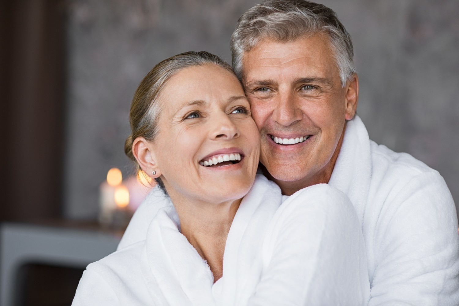 um homem e uma mulher em roupões sorrindo para a câmera