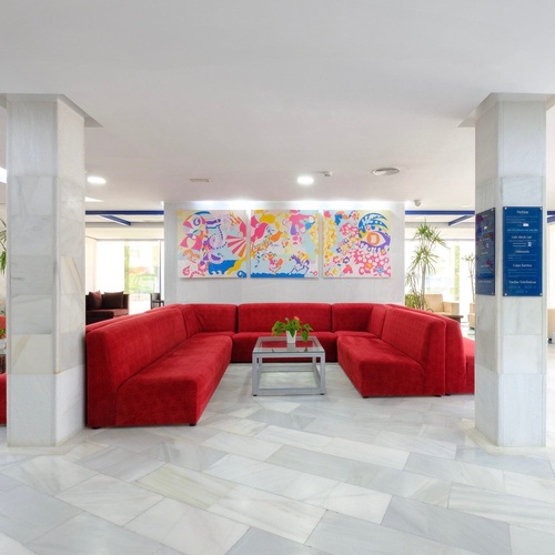 a lobby with red couches and a sign that says ' hotel ' on it