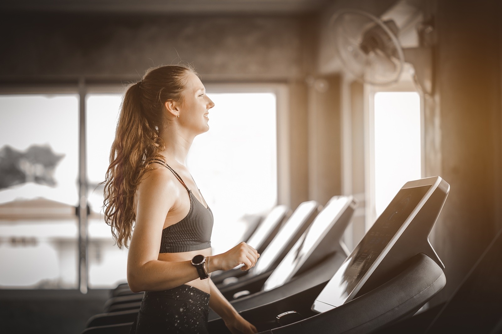 una mujer corre en una cinta de correr en un gimnasio