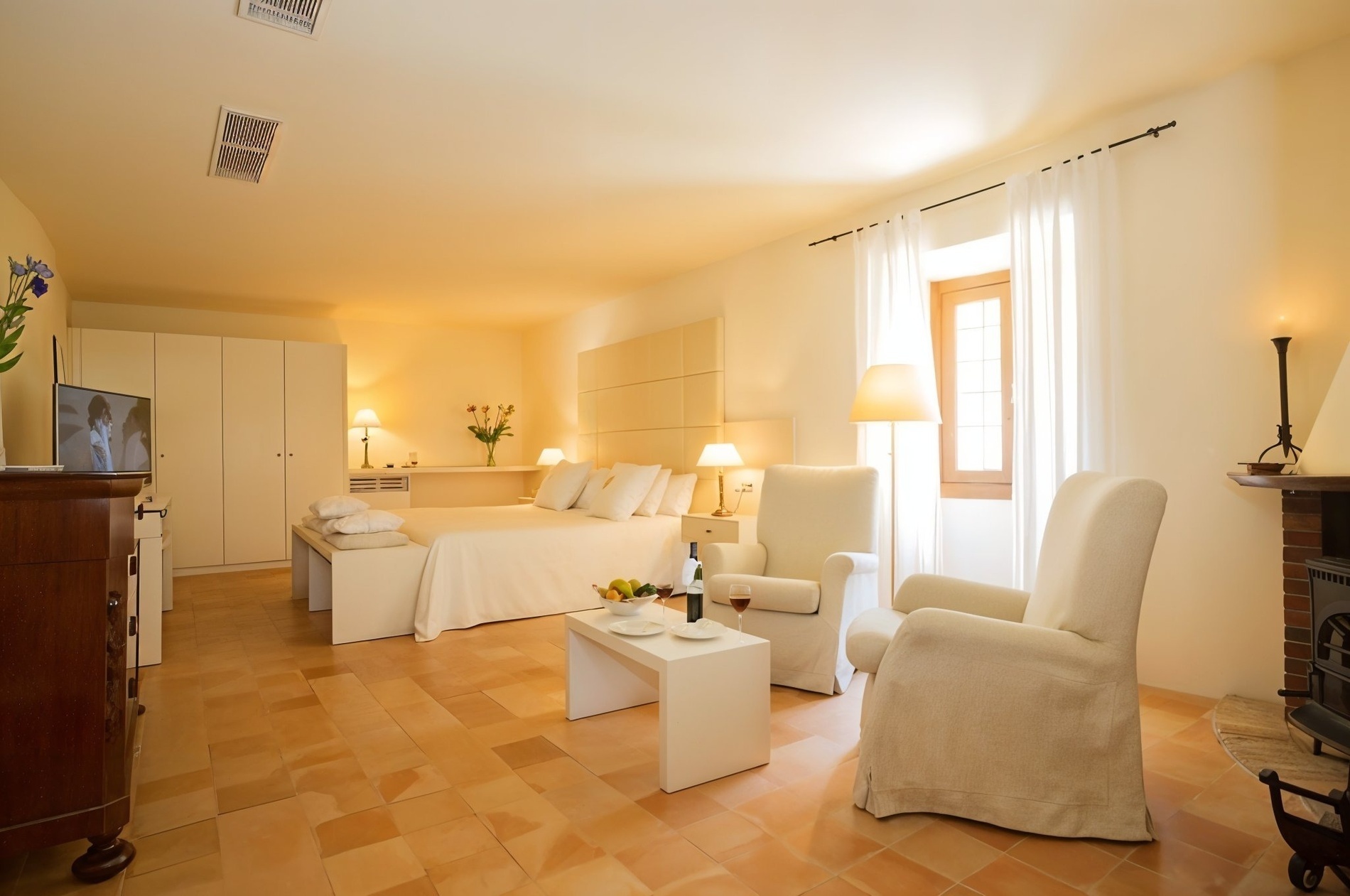 una habitación con una cama y dos sillas y una mesa con una botella de vino