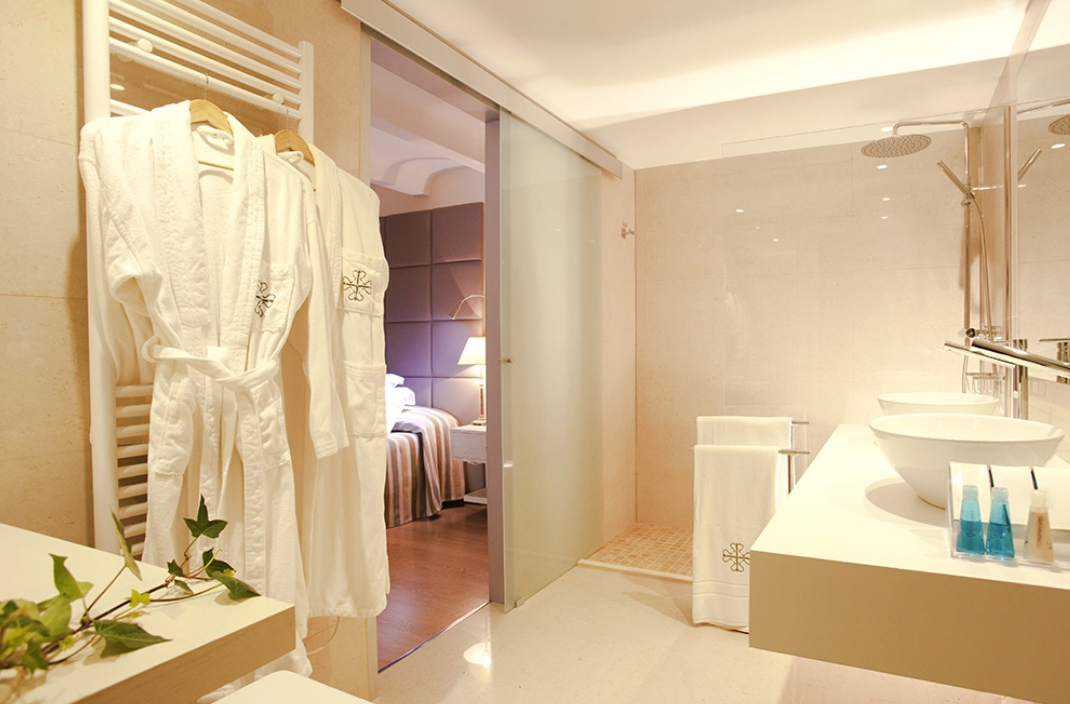 un baño con dos lavabos y una puerta corrediza de vidrio