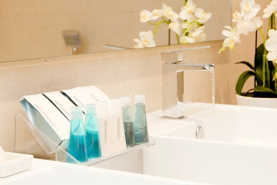 un baño con productos de belleza y un grifo